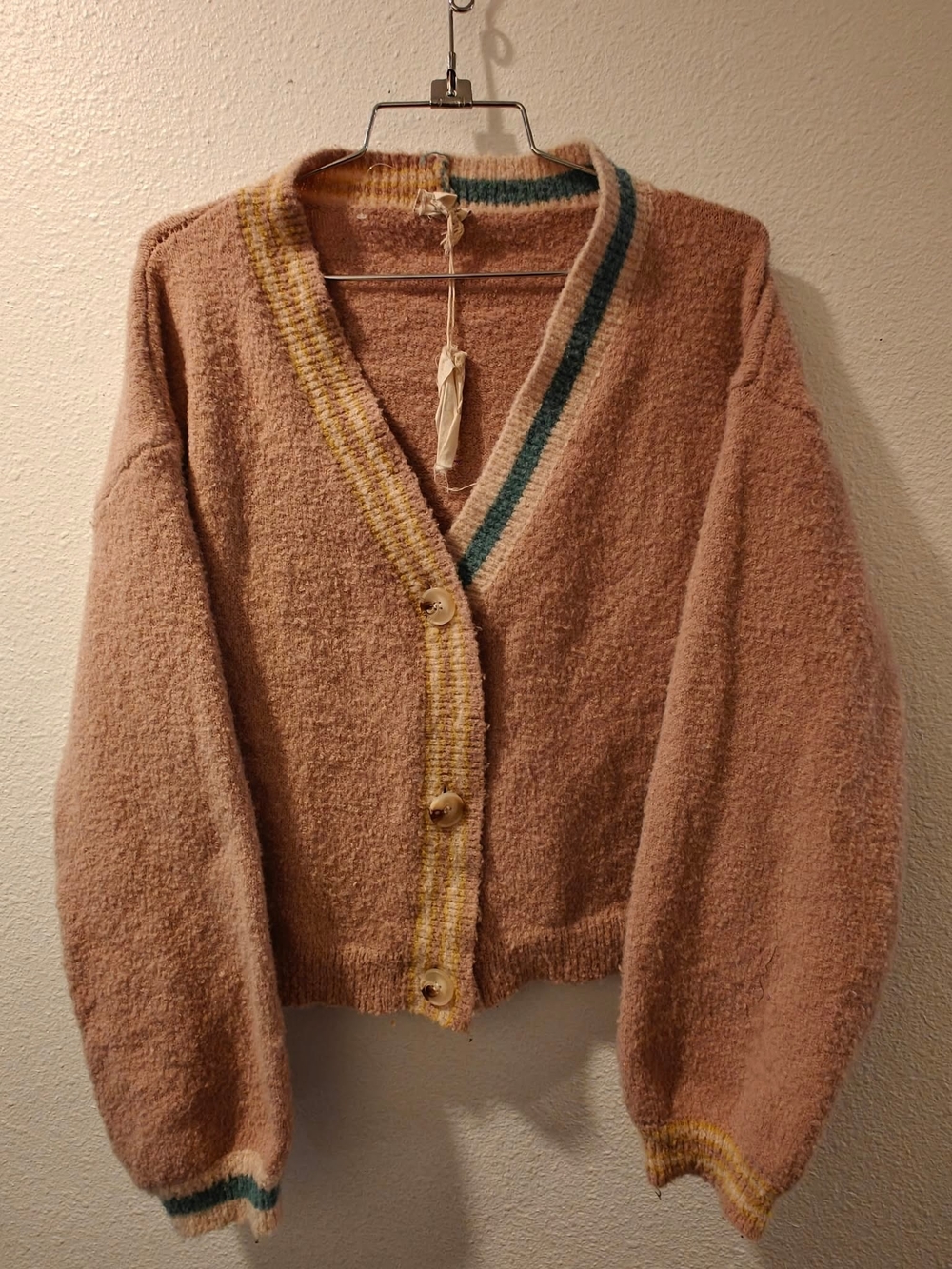 New
Cream knit cardigan with a relaxed V-neck. Button-front closure with